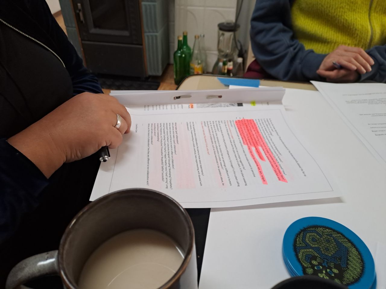 persons sitting around a table with a piece of marked up paper