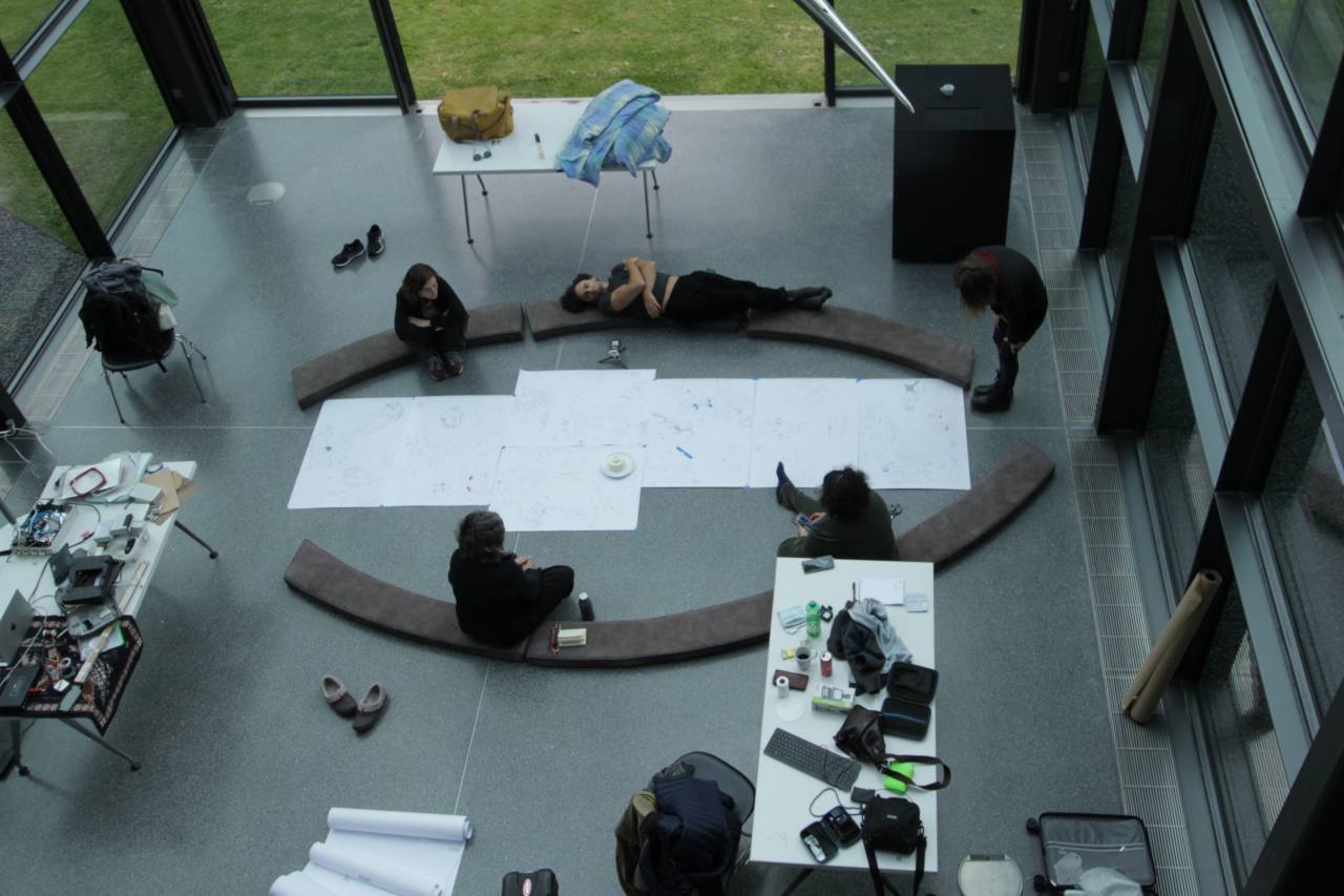 inside view of the cube space of Domenig Steinhaus with researchers gathering around papers on the floor